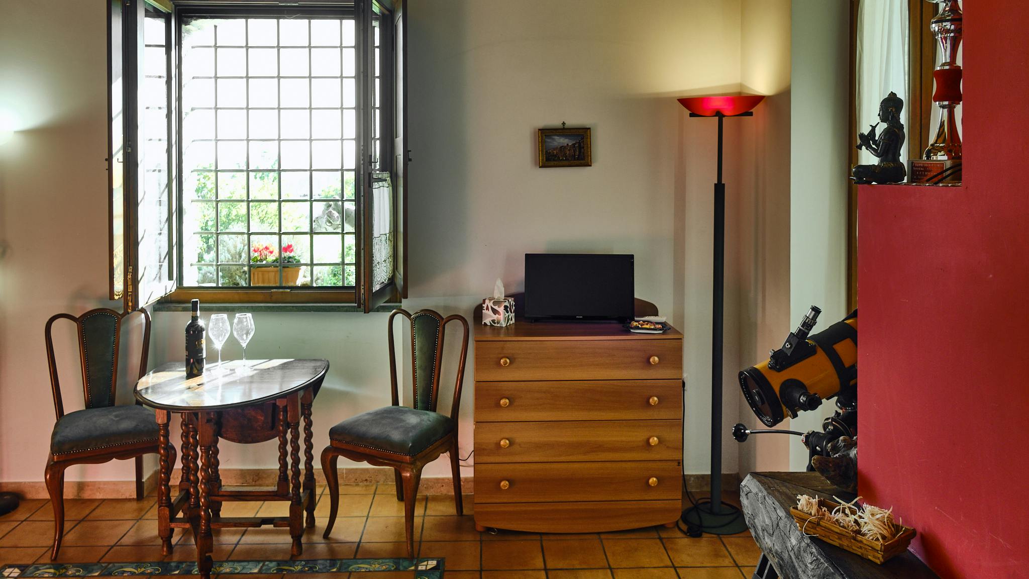 The interior of the Chalet is very well kept. In this photo on the right you can see the detail of the solid wood of the fireplace with a telescope and a buddha in the background.